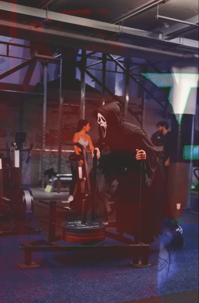 trick or treat - person in scream mask pushes a sled in the gym