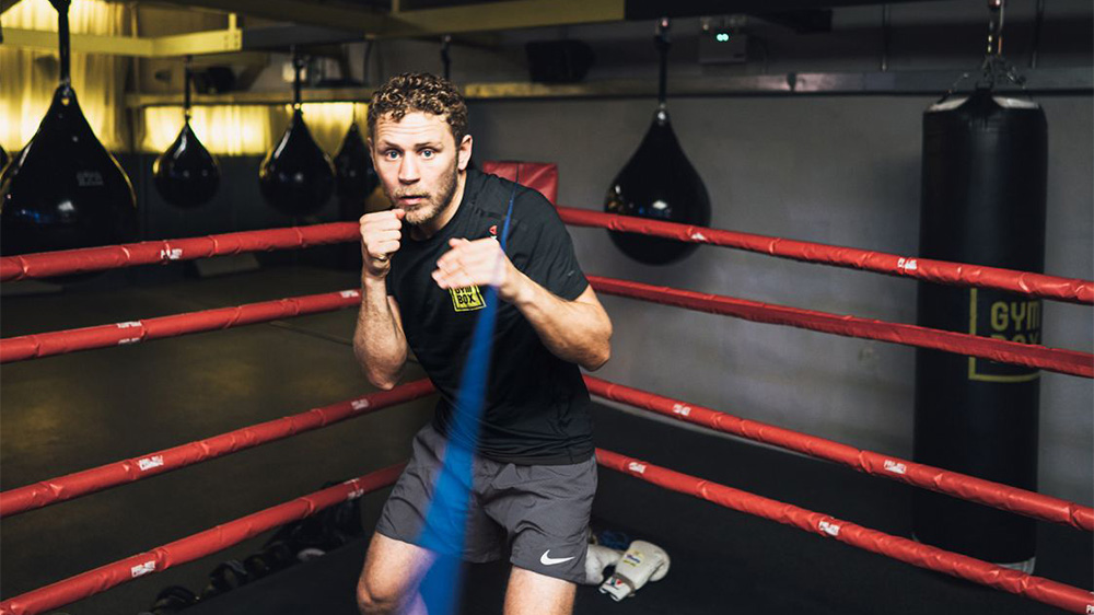 Boxing, a guy who is fighting towards the camera in the ring.