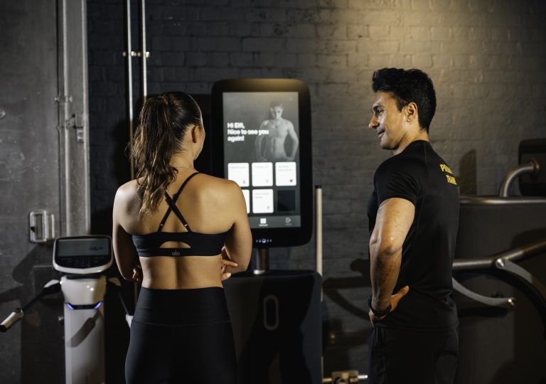 Egym, personal trainer and client interact with Egym machine