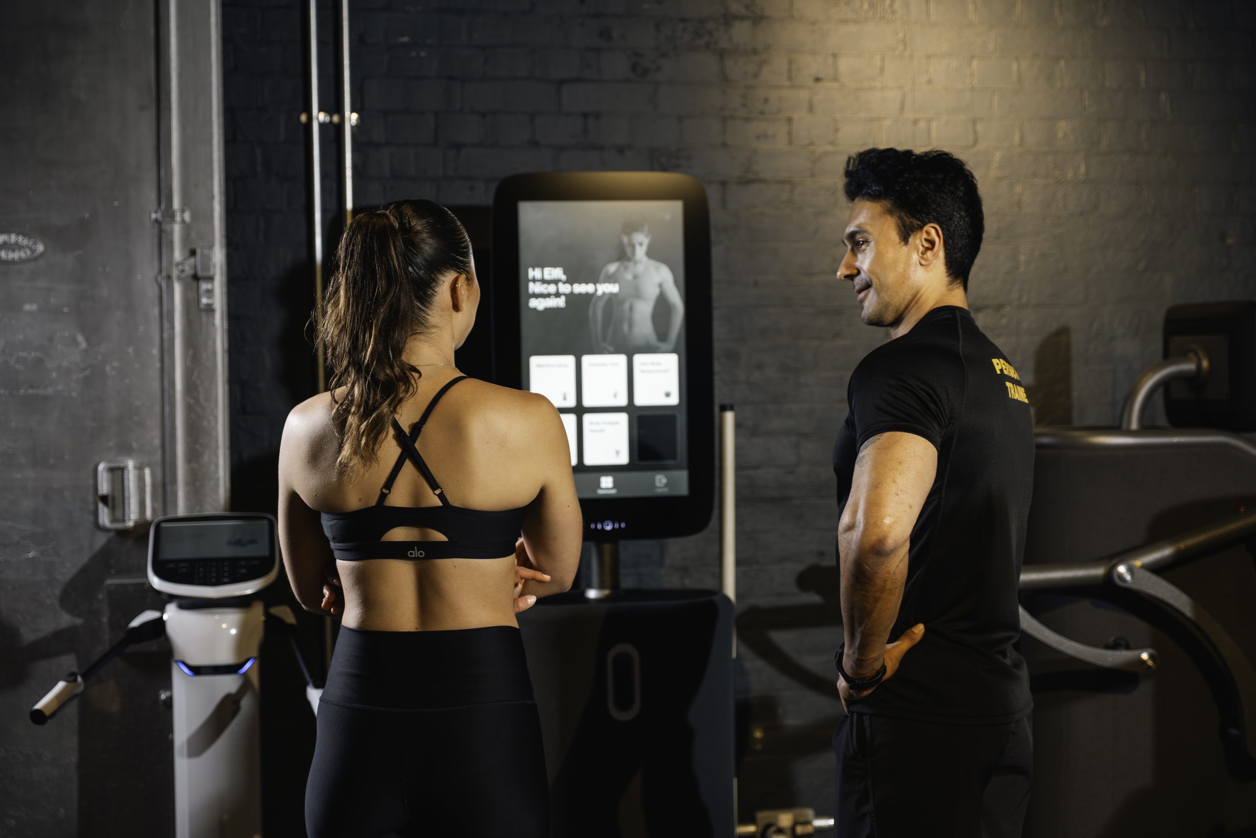 Egym, personal trainer and client interact with Egym machine