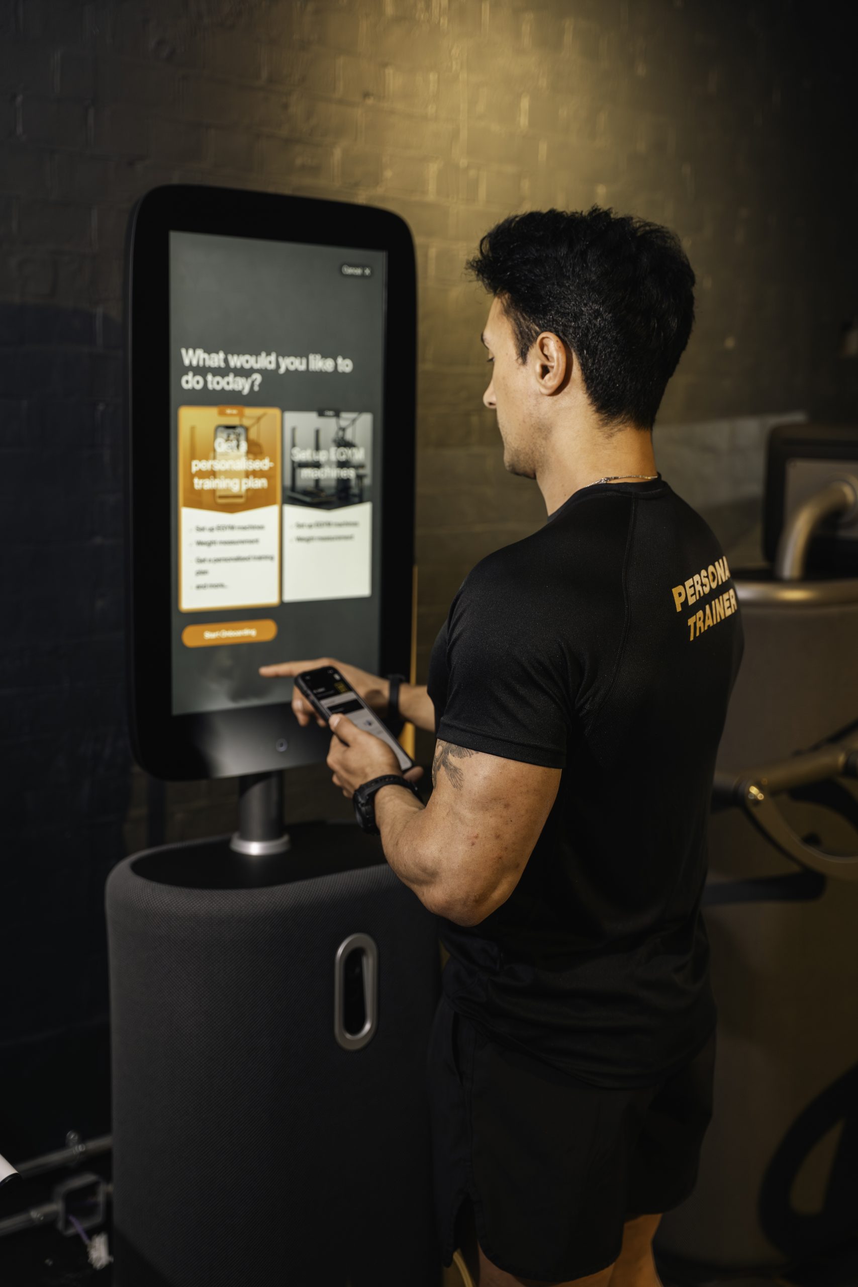 Egym, personal trainer interacts with Egym machine