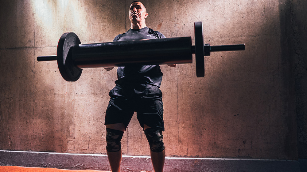 strongman - man lifts a log press