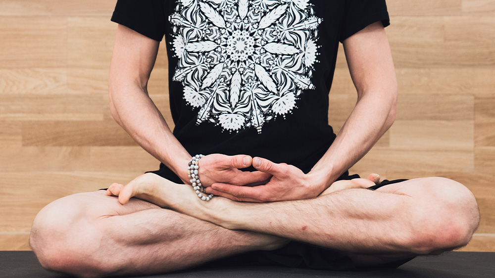 Yin Yoga - man sits in lotus pose