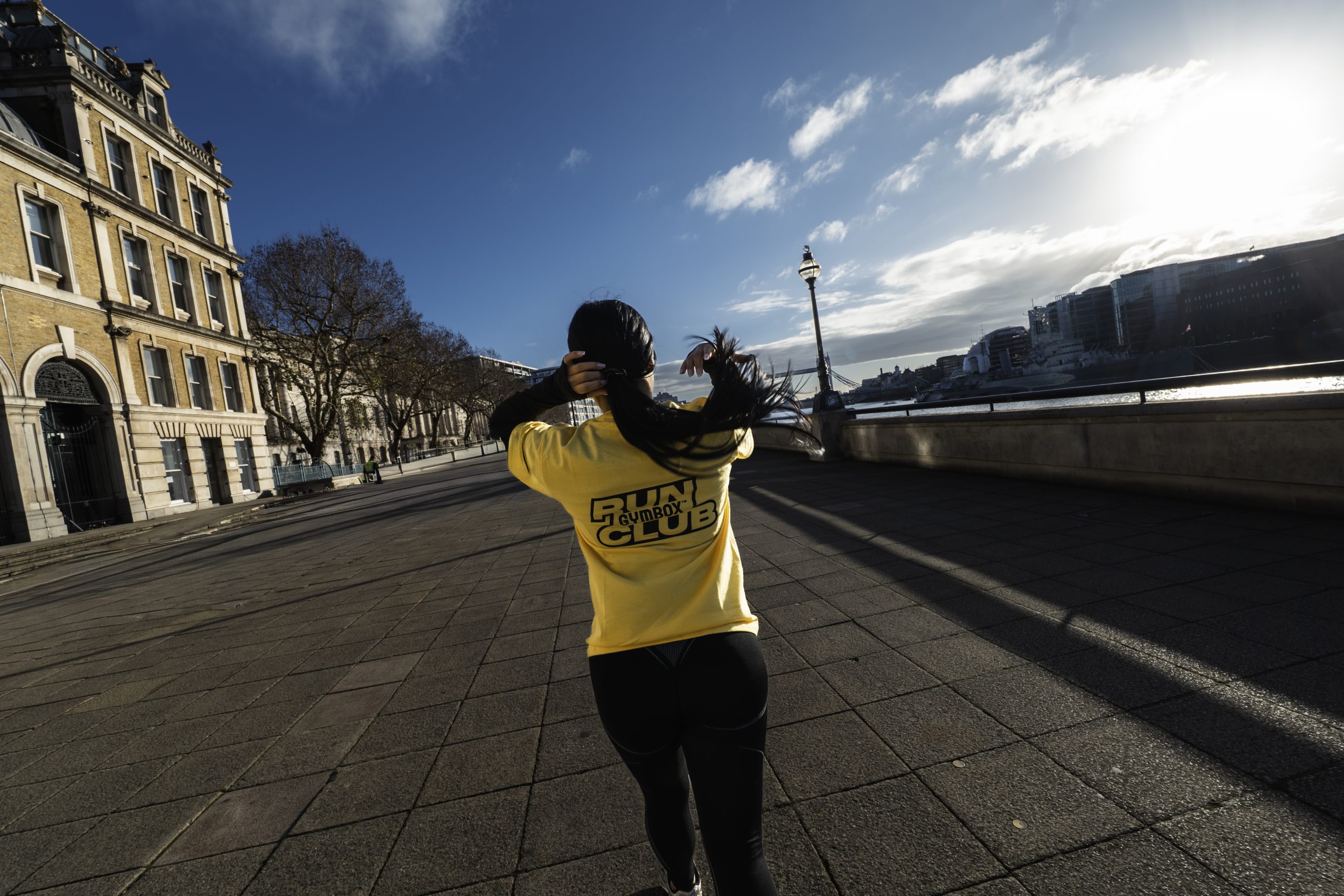 Gymbox Run Club. Woman runs through London