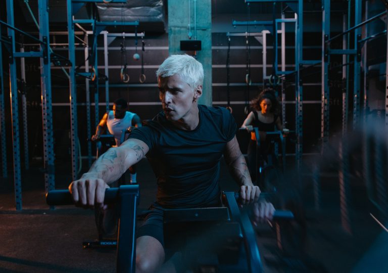 gymbox sweat class, man rides on echo bike in functional training area