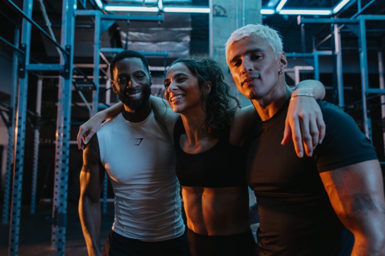 Gymbox Corporate Wellness - Three people embrace on gym floor