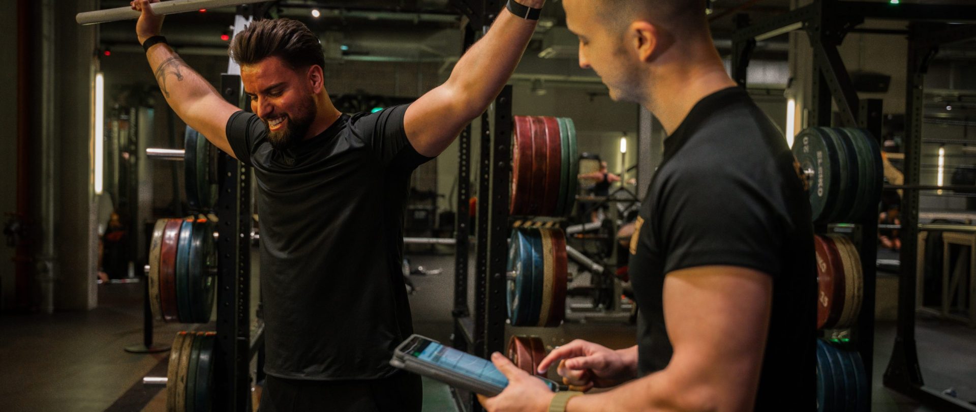 personal trainer coaches client in overhead position